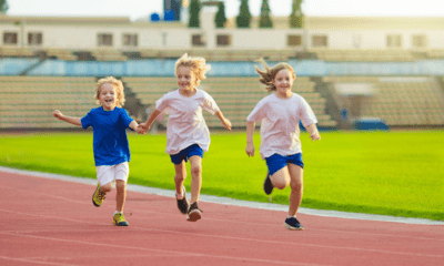 Atletiekpiste waarop drie kinderen lopen