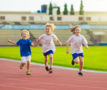 Atletiekpiste waarop drie kinderen lopen